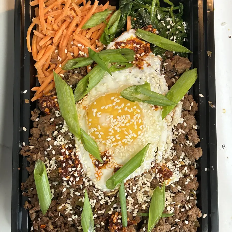 Korean beef bibimbap with carrot, spinach, scallions and a fried egg