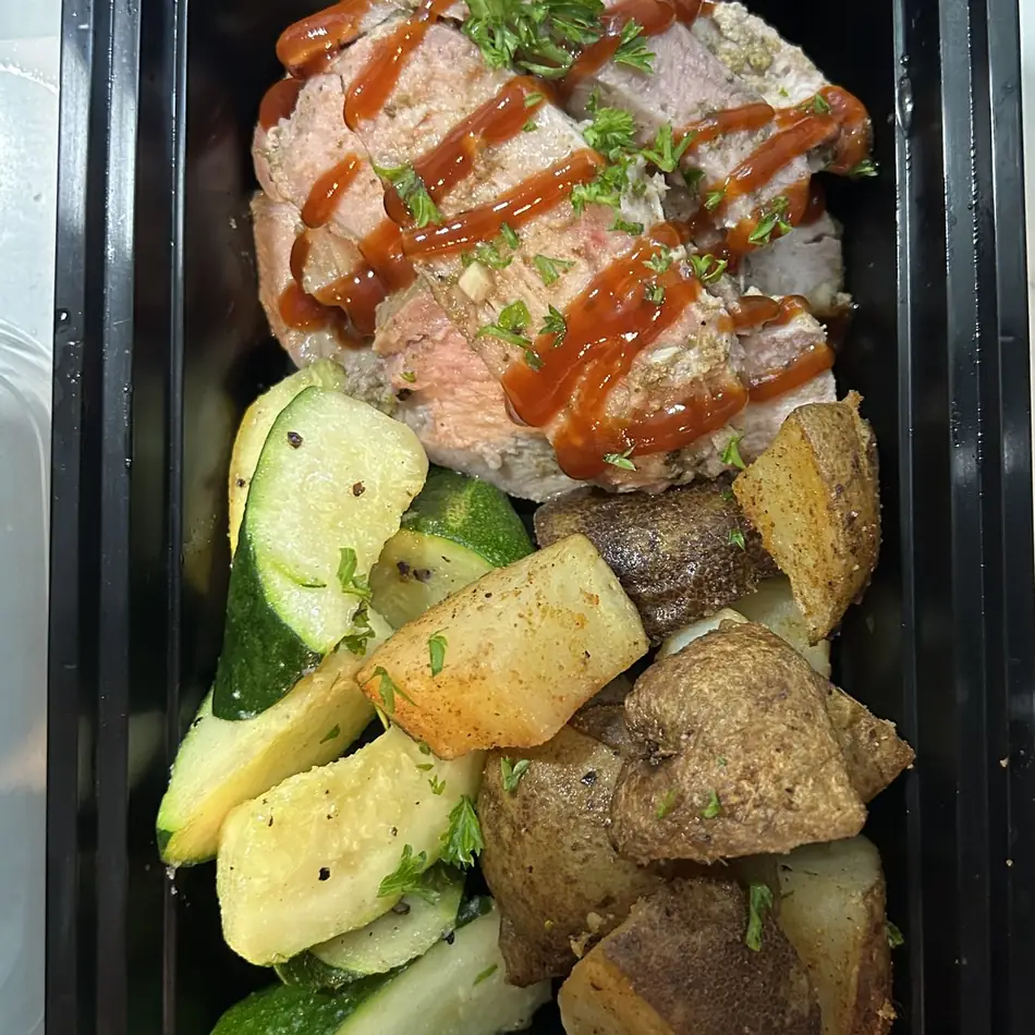 Slow smoked cajun pork loin with raspberry chipotle drizzle, roasted zucchini and potatoes